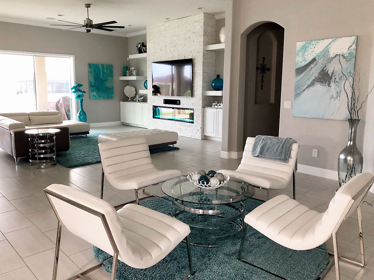 White Stacked Stone Fireplace in a modern styled living room with grey and white color tones and teal accents